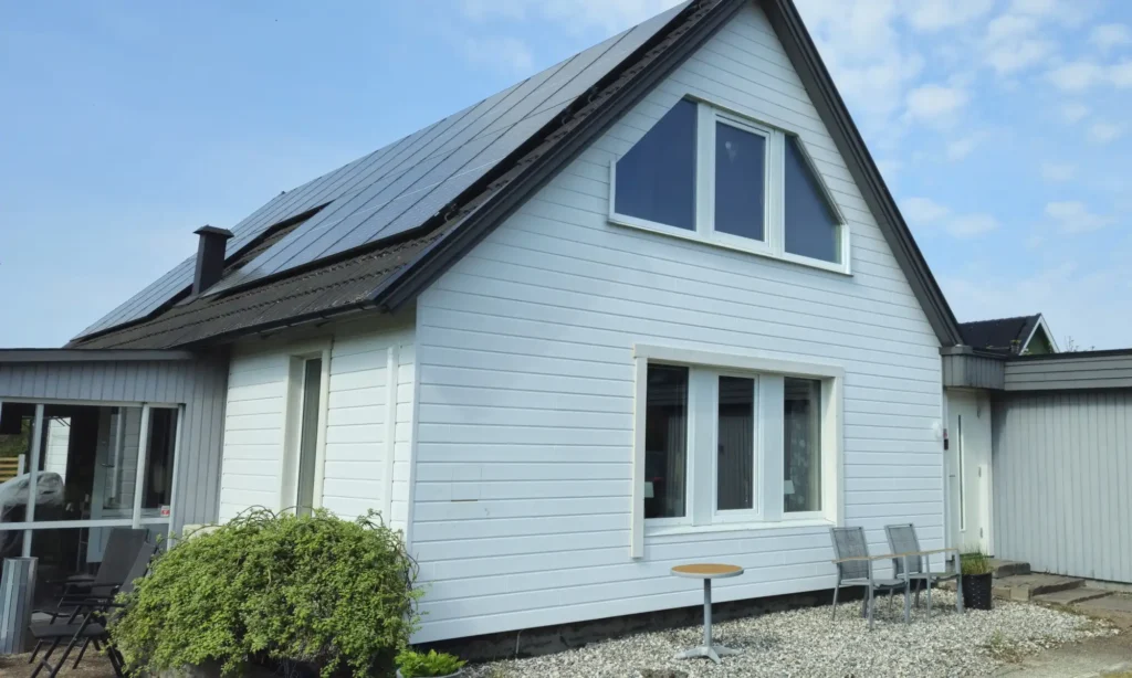 Exklusivpanelen monterad liggande med träknutar på ett hus i Eldberga