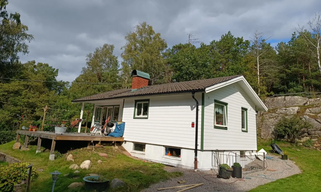 Exklusivpanelen från OnceWall på stuga i Ödsmål med gröna detaljer