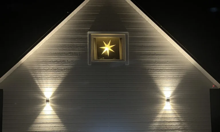 Nattfotografi av OnceWall Västkustpanel med upp- och nerbelysning på fasaden i Ödeborg